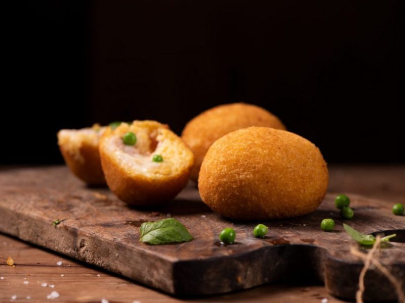 Sicilian Arancini made with fried risotto cheese ham and peas